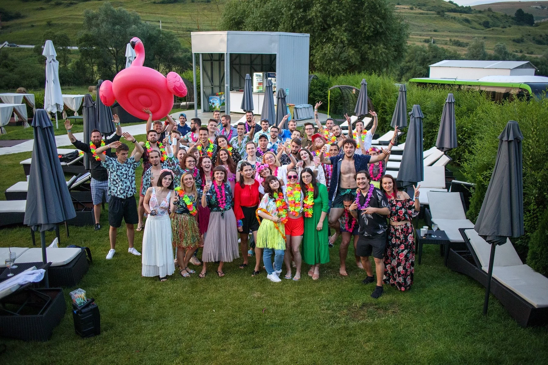 The full Wolfpack Digital team in Hawaiian shirts and colorful leis at the outdoor Howl-waii summer party